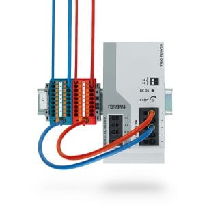 Ein blauer und roter Stromversorgungs-Verteilerblock von Phoenix Contact, montiert auf einer Hutschiene.
